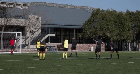 Youth Soccer Team Practicing Near Goal on Sunny Day