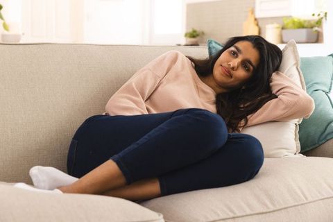 Young asian woman relaxing on comfortable sofa at home