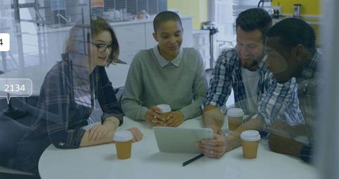Casual office meeting with diverse team collaborating around tablet