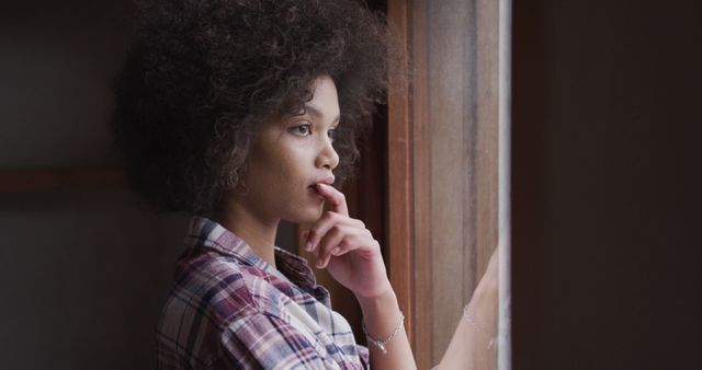 Thoughtful Young Woman Looking Out Window in Plaid Shirt - Download Free Stock Images Pikwizard.com