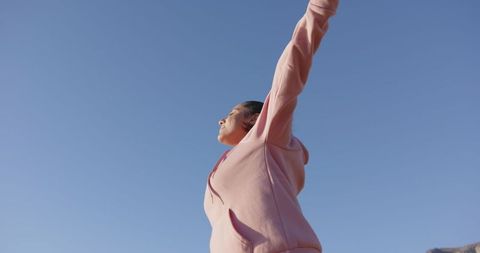 Woman Embracing Freedom Under Bright Blue Sky