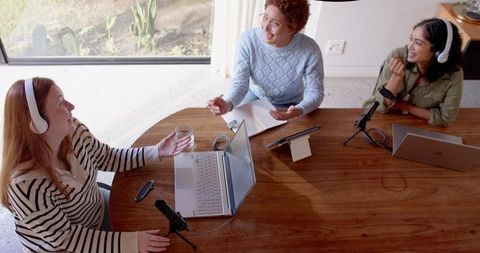 Diverse female podcasters recording at home studio