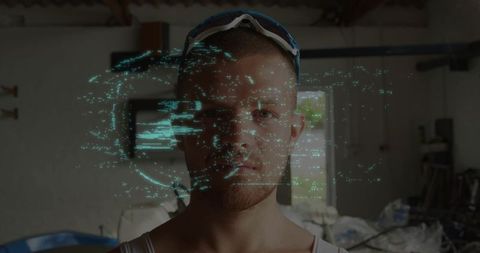 Mechanic standing in cluttered workshop wearing goggles and teal digital overlay