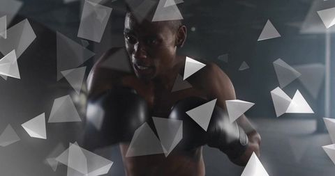 Moody low-light male boxer training with black gloves and triangular graphic overlays