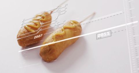 Golden corn dog skewers featuring mustard on white surface with sleek infographic timeline