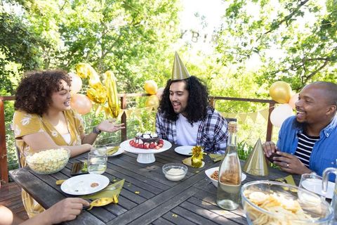 Diverse Friends Celebrating Birthday Outdoors with Cake and Balloons