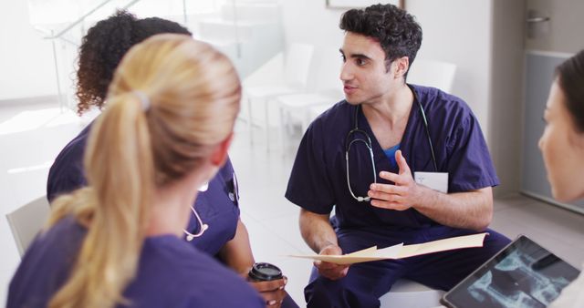 Image of biracial male doctor talking with diverse female doctors in hospital meeting. Hospital, medical and healthcare services.