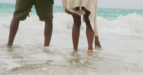 Couple Enjoying Beach Waves Together During Relaxing Day