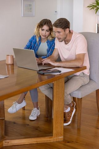 Couple Collaborating on Laptop at Home Desk