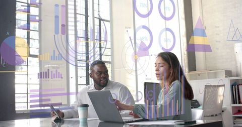 Diverse Colleagues Analyzing Data with Digital Graphs in Modern Office