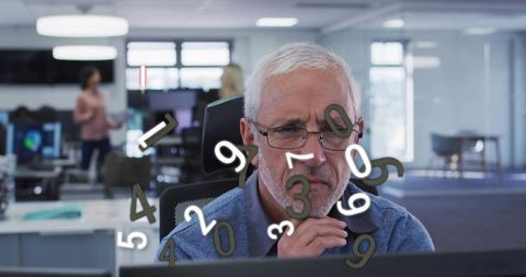 Senior analyst studying financial data with floating numbers overlay in modern office