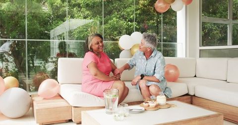 Senior Lesbian Couple Celebrating Birthday at Home Wearing Crowns