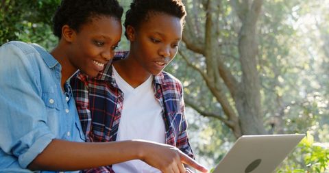 Twin Sisters Engaging with Laptop Outdoors - Download Free Stock Images Pikwizard.com