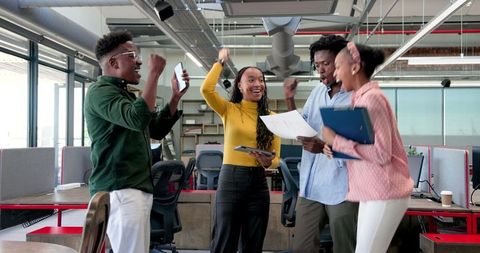 Joyful Diverse Team Celebrating Success in Modern Office Urban Setting