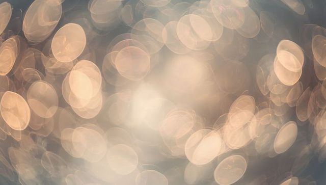 Glowing golden bokeh orbs with soft circular lens blur creating dreamlike ambient glow
