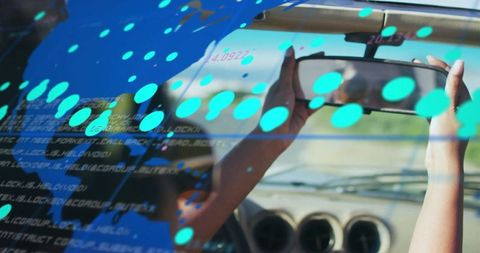 Woman adjusting rear-view mirror with digital futuristic overlay