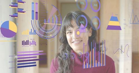 Young woman viewing holographic analytics dashboard in corridor with colorful charts