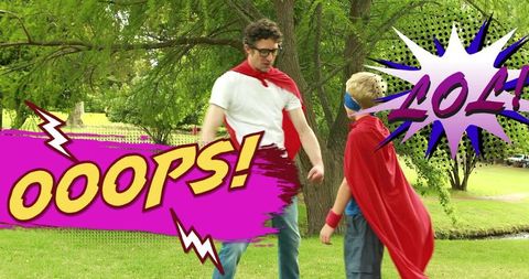 Dad and son playing superhero roleplay in park wearing red capes and blue mask comic ooops