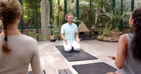Yoga Instructor Leading Class in Greenhouse Environment