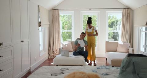 Couple Preparing for Vacation Together in Bright Bedroom