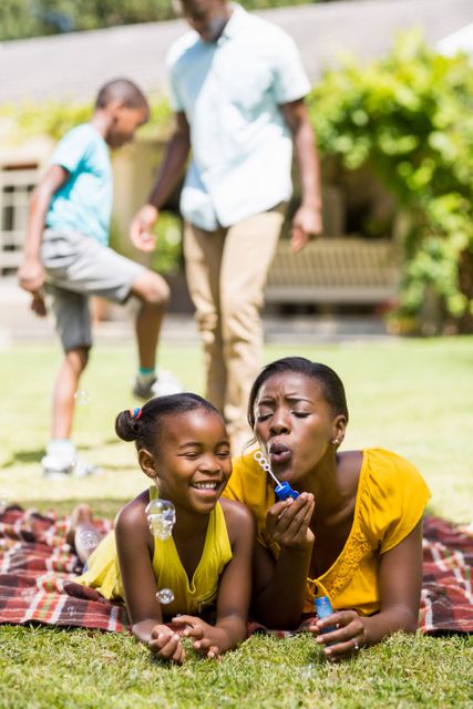 Happy African American Family Blowing Bubbles in Backyard - Download Free Stock Photos Pikwizard.com