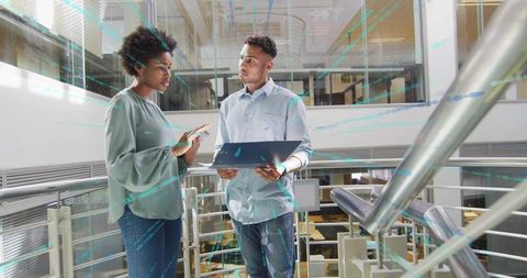Coworkers Collaborating with Technology in Modern Office Atrium