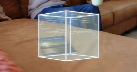 Holographic code cube hovering over ottoman in cozy living room