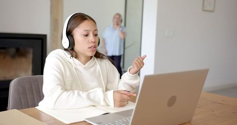 Teen Girl Engaged in Remote Learning with Laptop and Headphones