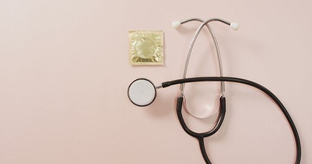 Condom and stethoscope on light pink background representing the importance of safe sex and sexual health. Suitable for health awareness campaigns, educational materials, medical articles, and social media posts promoting safe sex practices.