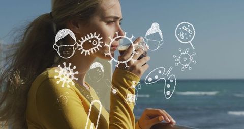 Woman Enjoying Coffee by Sea Amid COVID-19 Masks and Icons