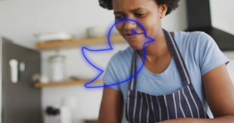 Woman chopping vegetables in kitchen with bird neon overlay