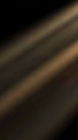 Vertical abstract video starting out of focus showing diagonal beige and black streaks