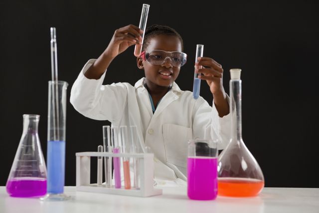 Young schoolgirl conducting a chemical experiment in a laboratory setting. She is wearing a lab coat and safety goggles, handling test tubes with colorful liquids. Ideal for educational content, science and technology promotions, STEM programs, and school projects.