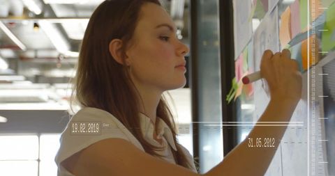 Professional Woman Planning on Office Whiteboard with Financial Overlay