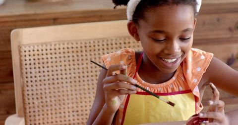 African American Child Joyfully Painting at Home