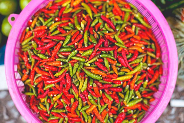 Colorful Thai Chili Peppers in Pink Basket at Market - Download Free Stock Photos Pikwizard.com