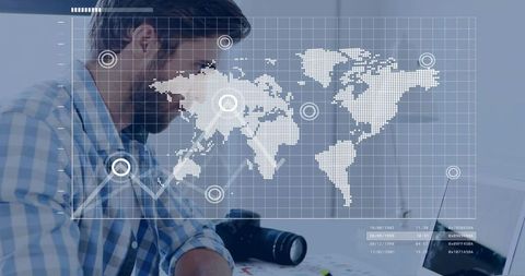 Photographer editing global map overlay on laptop with dslr, geospatial grid