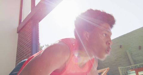 Athletic man doing push-ups in sunlit room exercising at home