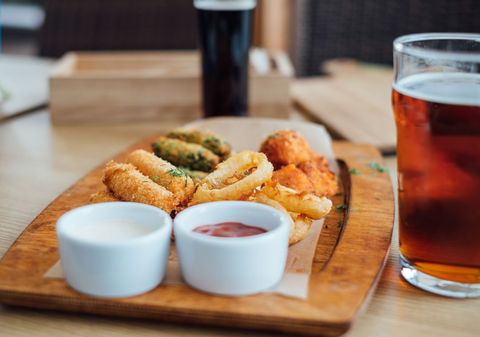 Assorted fried appetizers with dipping sauces and beverages