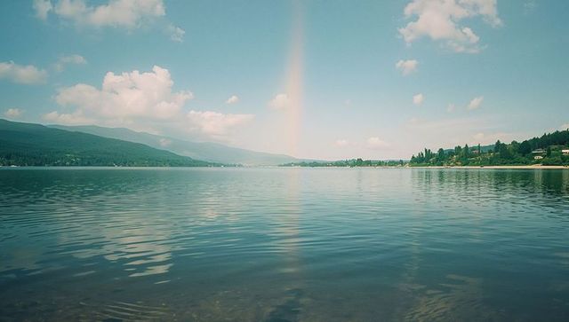 Tranquil lake with rainbow reflection and mountain scenery