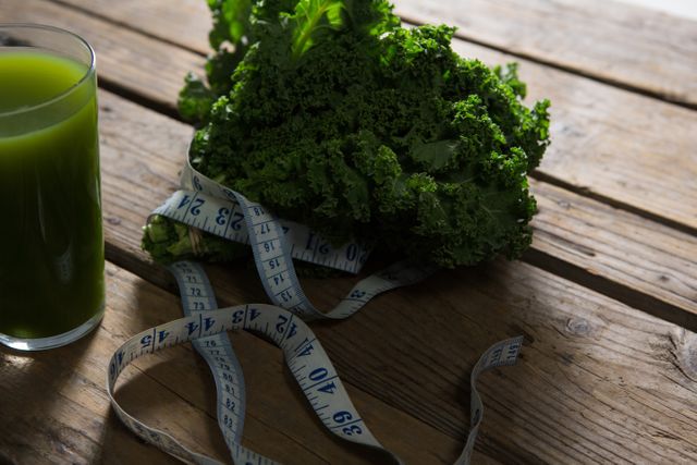 Mustard greens, measuring tape and juice on wooden table - Download Free Stock Photos Pikwizard.com