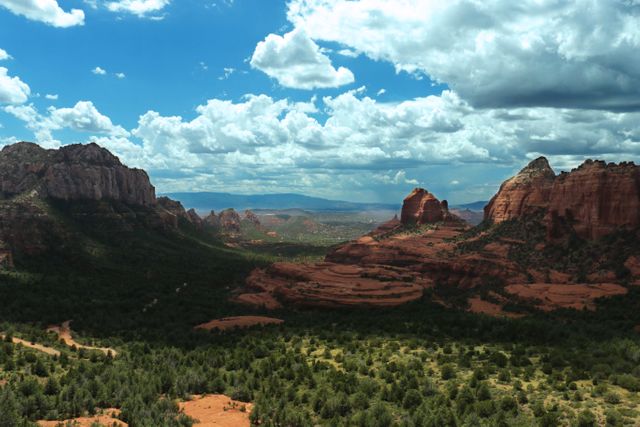 Perfect for promoting travel destinations, nature documentaries, outdoor adventure blogs, and desert landscapes. Highlights dramatic clouds contrasting with red rock formations.