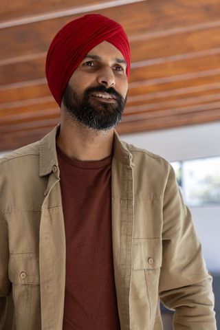 Confident professional in modern office wearing red turban