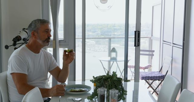 Man Enjoying Breakfast in Modern Apartment with Scenic View - Download Free Stock Images Pikwizard.com