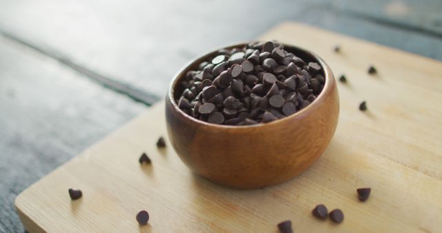 Bowl filled with dark chocolate chips on a wooden board. Perfect for baking blogs, dessert recipes, and culinary websites.