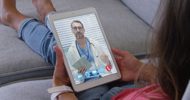 Woman interacting with a doctor through a video call on a tablet. Perfect for illustrating concepts related to telemedicine, digital health services, virtual medical consultations, and remote patient care.