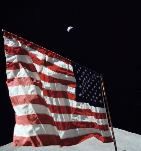 Iconic portrayal of American flag on lunar surface with distant crescent Earth and Moon's South Massif backdrop; suitable for educational, historical and space exploration themes.