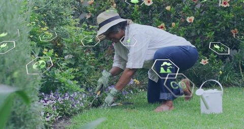 Elderly woman kneeling in garden wearing straw hat and gloves using trowel with ar gardening icons