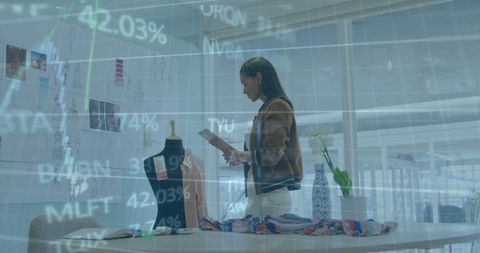 Fashion Designer Analyzing Trends Amid Stock Market Graphics