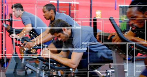 Men pedaling intensely in high-energy spin class with digital performance overlays
